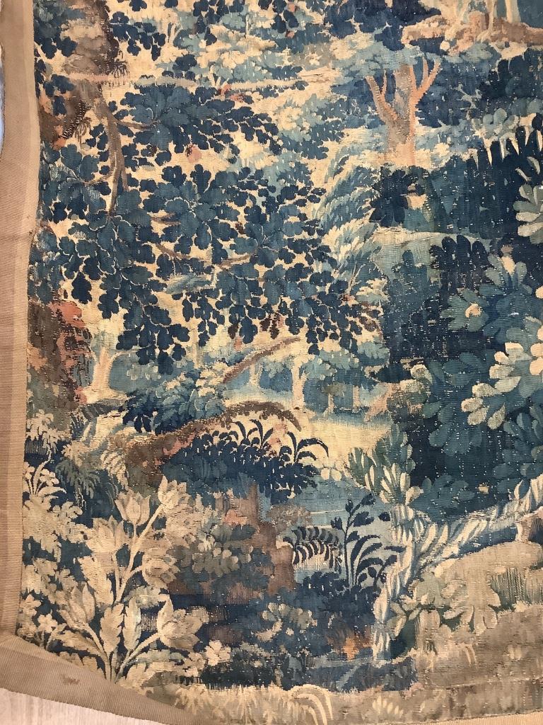 An early 17th century Aubusson tapestry, worked with a peacock in a landscape (worn in places and reduced)